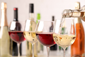 Pouring white wine from bottle into glass, closeup