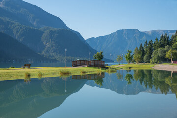 Fototapeta premium morning scenery lake Achensee, calm water with reflection. small bridge.