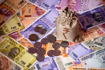 New Indian currency bank notes flat lay with coin and money bag. Top view of cash wealth on a table.