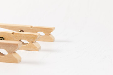 three wooden clothespins with a metal spring on the background of a white wooden table. close-up. selective focus
