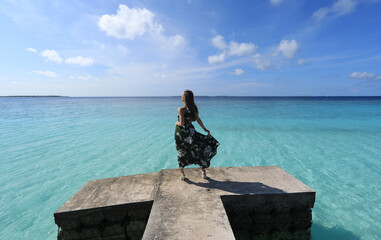 girl in a dress on a pier in the ocean