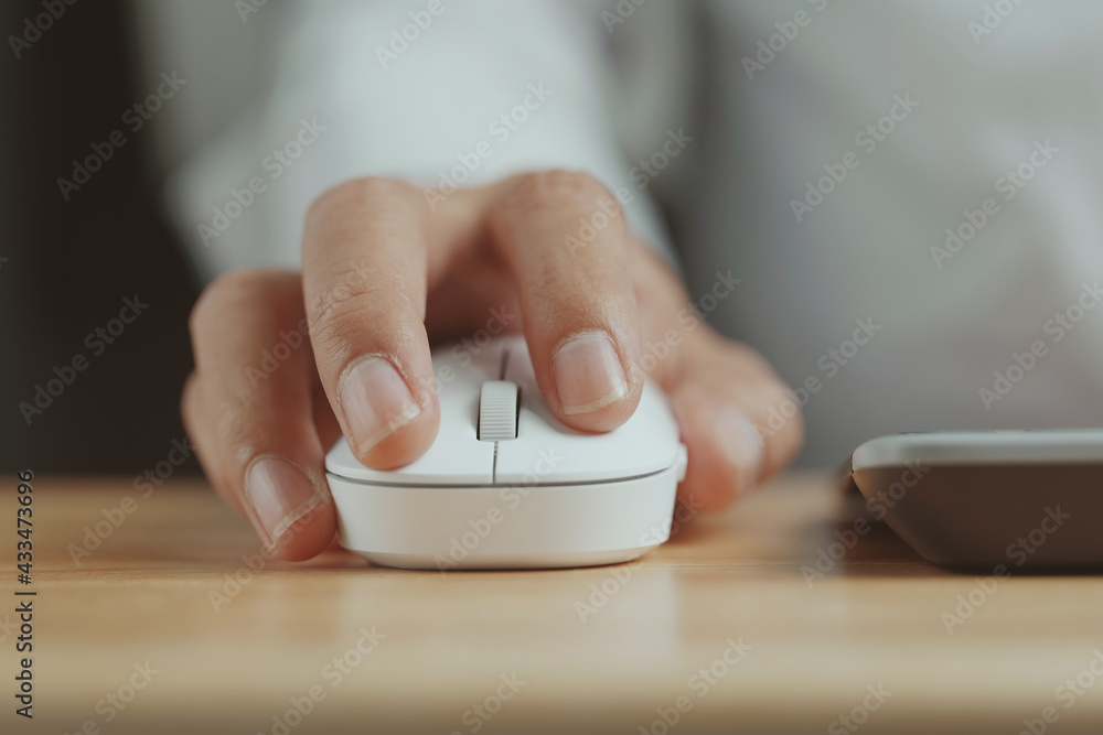 Poster Click white computer mouse on a work desk. Working with a PC or laptop