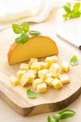 Smoked cheese on cutting board with basil, sliced cheese