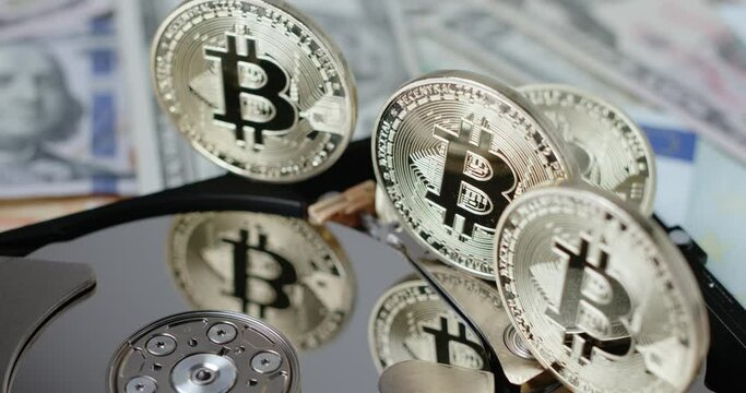 Gold Bitcoin reflecting on silver disk. Hard Drive open. Concept of crypto mining and blockchain storage
