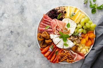 Charcuterie assortment, variety of cheeses and salami, prosciutto and dried fruits, figs, apricots,...