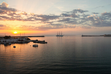 Naklejka na ściany i meble Tourist ship entering the port at sunset