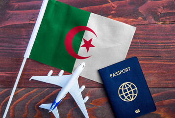Flag of Algeria with passport and toy airplane on wooden background. Flight travel concept.
 - obrazy, fototapety, plakaty
