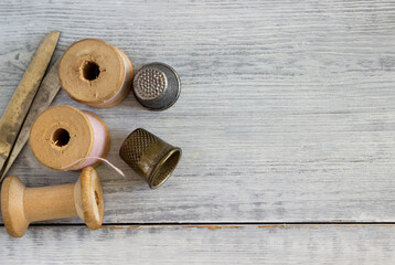 Set of vintage sewing spools, scissors and partner thimbles.
