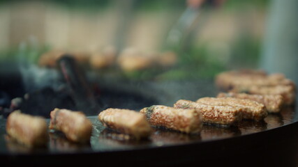 Man preparing meat snacks on grill. Chef turning around meat kebab on bbq grill
