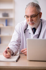 Old male doctor in vaccination concept