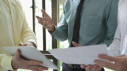 Asian business people meeting new startup project pointing graph discussion and analysis data charts and graphs.Business finances and accounting concept