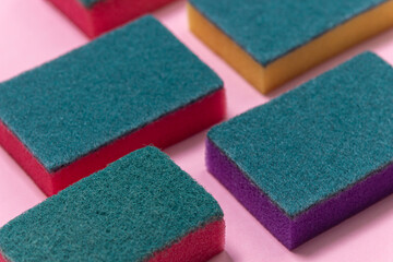 Washing sponges on a pink background. Cleaning sponges on a colored background. Indoor washing and cleaning tools.