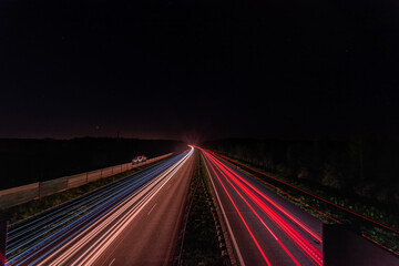 smugi świateł samochodów na autostradzie w ciemną noc - obrazy, fototapety, plakaty