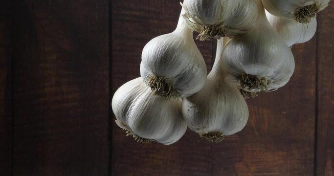 The harvest of a bunch of garlic hung drying and spinning slowly