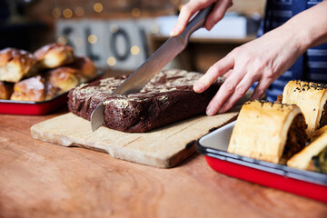 Sales Assistant In Bakery Cutting Freshly Baked Baked Brownies On Counter