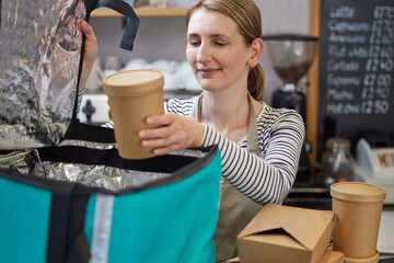 Female Restaurant Worker Packing Insulated Bag For Takeaway Food Home Delivery