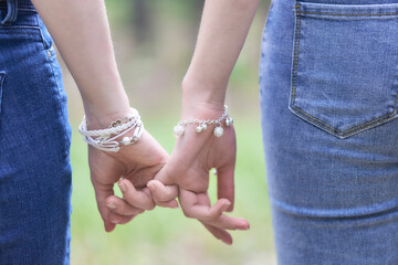 Two women holding hands in a park