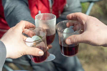 three plastic cups of wine. make a toast on a picnic