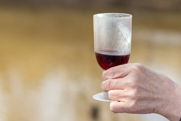 plastic wine glass in women's hands close-up