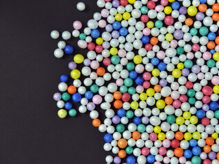 Obraz premium Multicolored thermocol (polystrene) balls on black background.