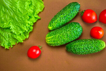 Fresh red cherry tomatoes, green cucumbers and lettuce. Sveru view.