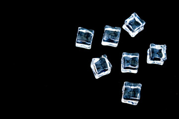 Clear ice in cube shape. Frozen water.Fake or Artificial acrylic or plastic ice cubes. Black background.copy text food background.