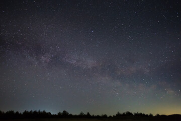 Fototapeta na wymiar night starry sky with milky way above prairie silhouette