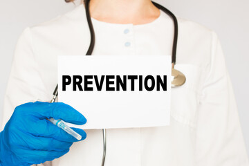 the doctor in gloves holds a card with the text PREVENTION . white background. the medicine