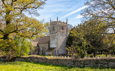 Fototapeta na wymiar St Mary's Church, Beverston. A 12th Century Norman church with an original Norman Tower. Beverston is a small Cotswolds village, Gloucestershire, United Kingdom