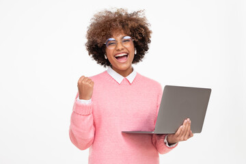 She is a winner! Excited young girl with laptop isolated on gray background