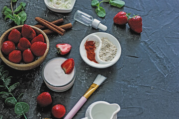 Ingredients homemade strawberry face mask, cream, strawberry, oatmeal, spices, herbs on a dark background, top view, copy space, flat lay/ Home hand-made cosmetics made from natural ingredient