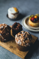 pasteles y panettone sobre tabla de madera y fondo de piedra 