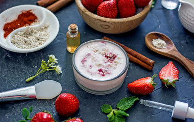 Homemade strawberry face mask with oatmeal and cream on a dark background. Concept of natural handmade cosmetics