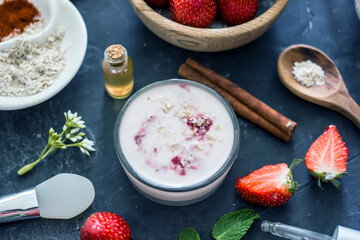 Homemade strawberry face mask with oatmeal and cream on a dark background. Concept of natural handmade cosmetics