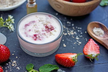 Homemade strawberry face mask with oatmeal and cream on a dark background. Concept of natural handmade cosmetics
