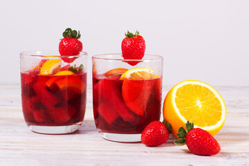 Fototapeta na wymiar Cocktail drink-orange juice fresh juice with strawberry with lemon orange, mango, pineapple, apple, grapes isolated on white background. High-resolution image