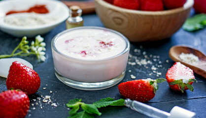Homemade strawberry face mask with oatmeal and cream on a dark background. Concept of natural handmade cosmetics
