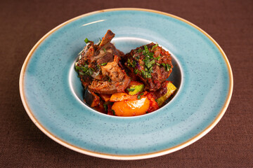 Stewed beef with potatoes and vegetables in a blue plate