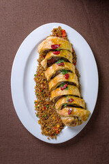 baked roll with meat and rice on a white plate. top view