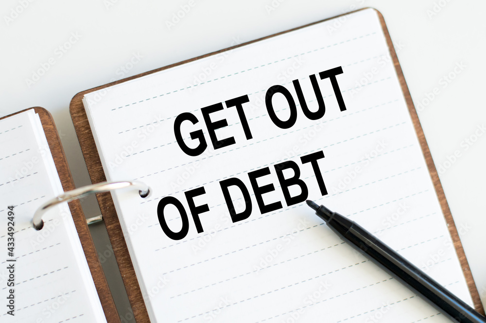 Poster open notepad with text get out of debt beside black marker
