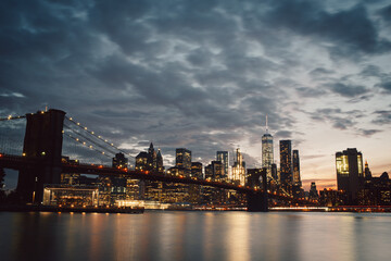 Fototapeta na wymiar The New York City skyline from Dumbo at sunset low exposure