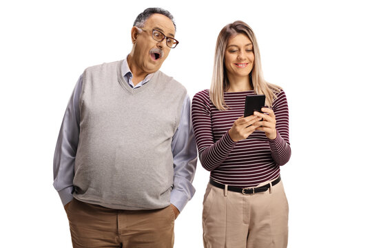 Surprised mature man spying a young woman typing on a smartphone