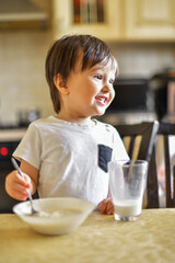 little boy eats breakfast, eats porridge and drinks milk 