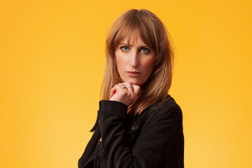 Portrait of an attractive brunette woman against a yellow background