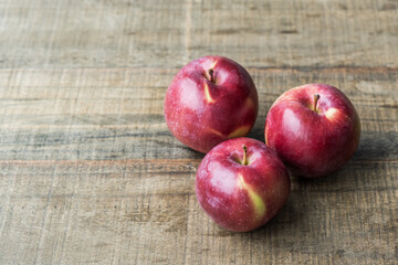 group of three fresh red apples on a wooden tabletop fruit diet