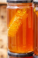 Jar of fresh honey with a piece of panel, food concept.