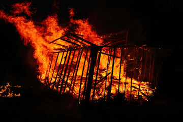Burning wooden building at night, close up view - Powered by Adobe