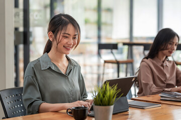 Asian beautiful smiling businesswoman is happy to work on a tablet at the office.