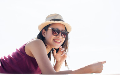 Asian beautiful adorable young woman wearing casual shirt, lying down on boat or ship for traveling outdoor in summer time, smiling with happiness, reading book, looking at camera. Lifestyle concept.