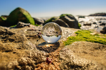Selective focus on rock with other elements in blur and defocused, with inverted reflective ball